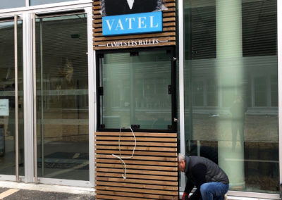 Vatel Campus des Halles - Bordeaux Conception et création totem caisson lumineux LED structure aluminium et bois intégration d'écran dans sa vitrine ouvrante l'atelier enseignes bordeaux